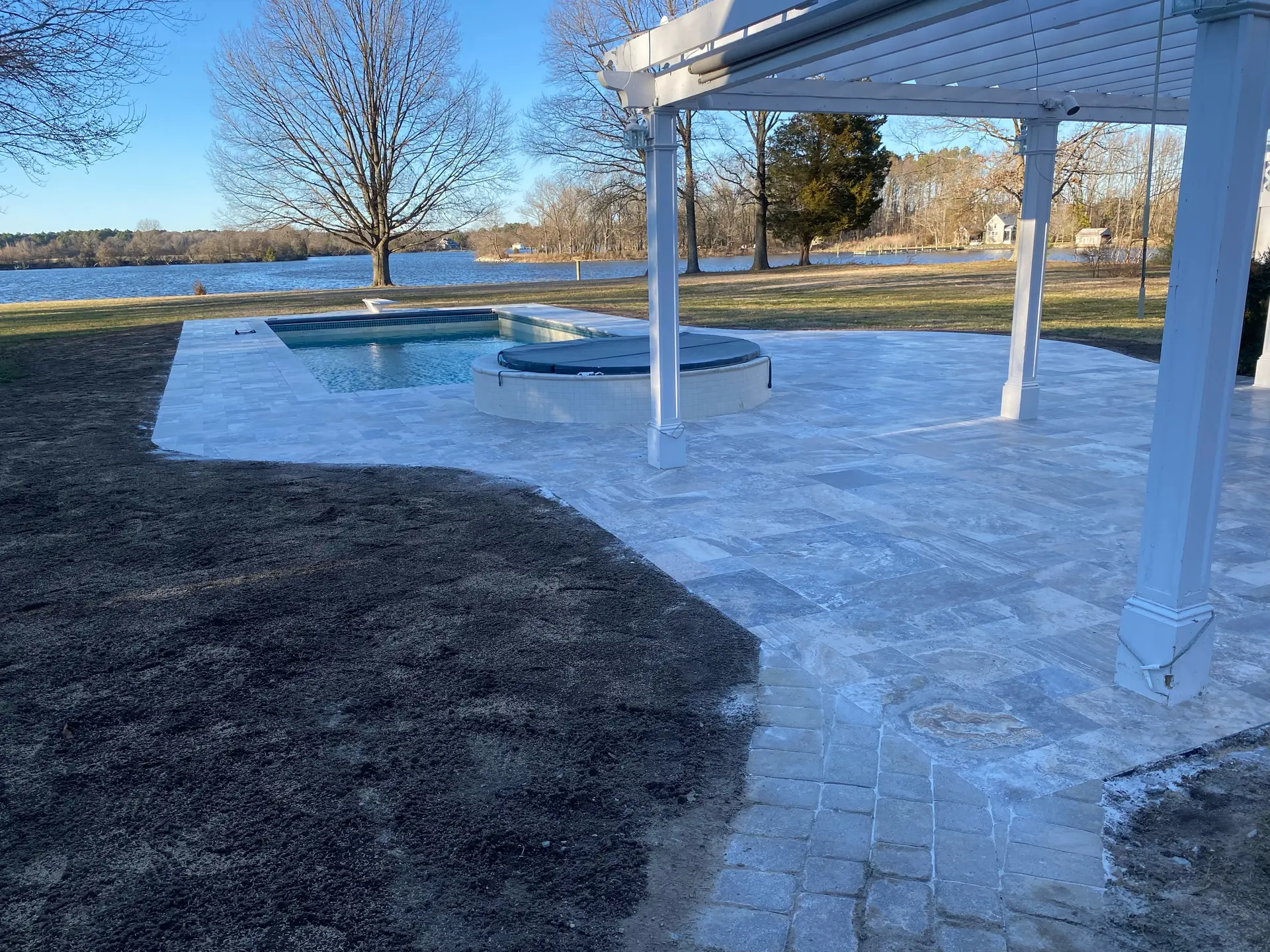 Completed backyard pool patio installation by DM Hardscapes