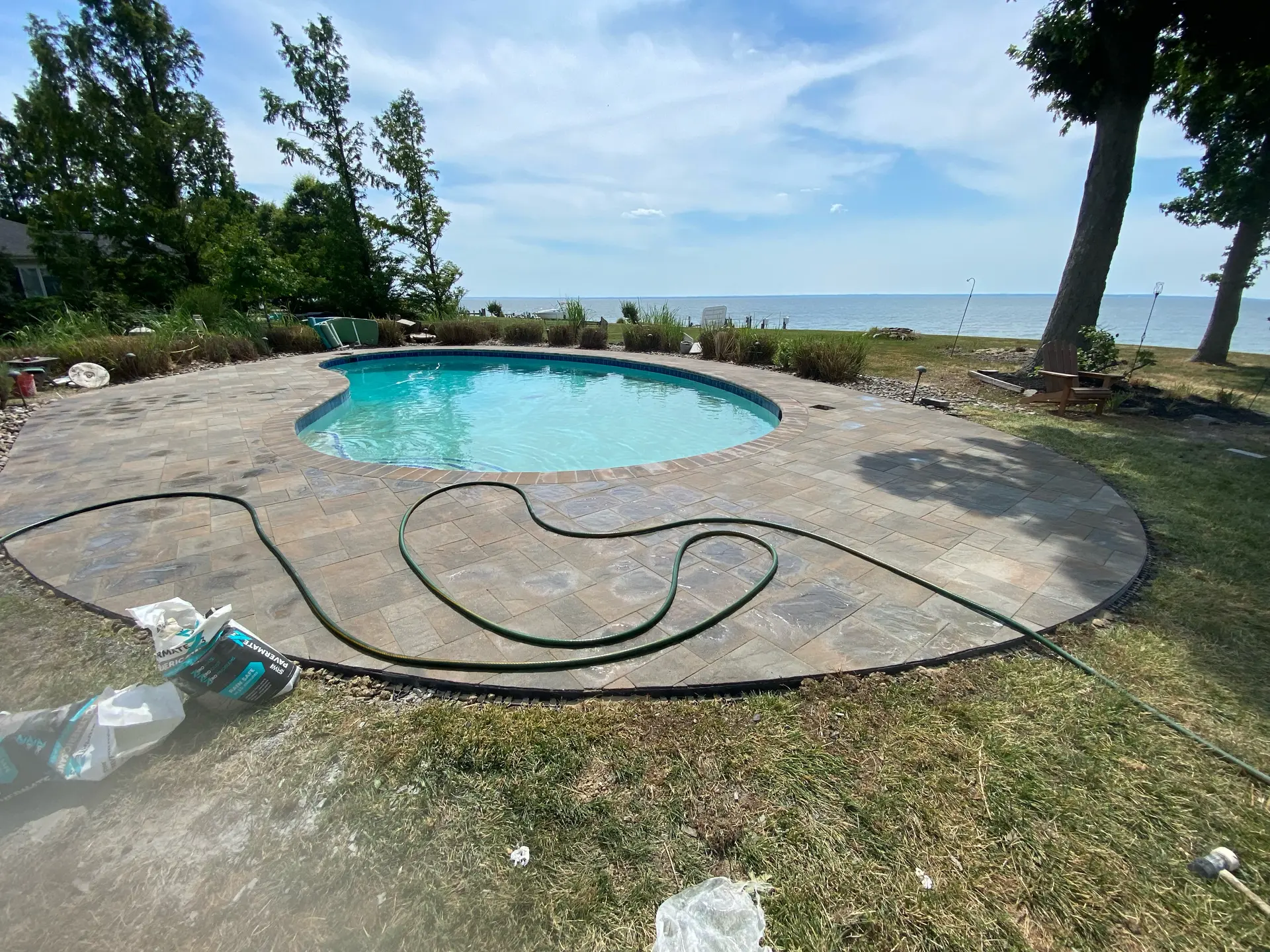 Completed backyard pool paver patio hardscaping by DM Hardscapes