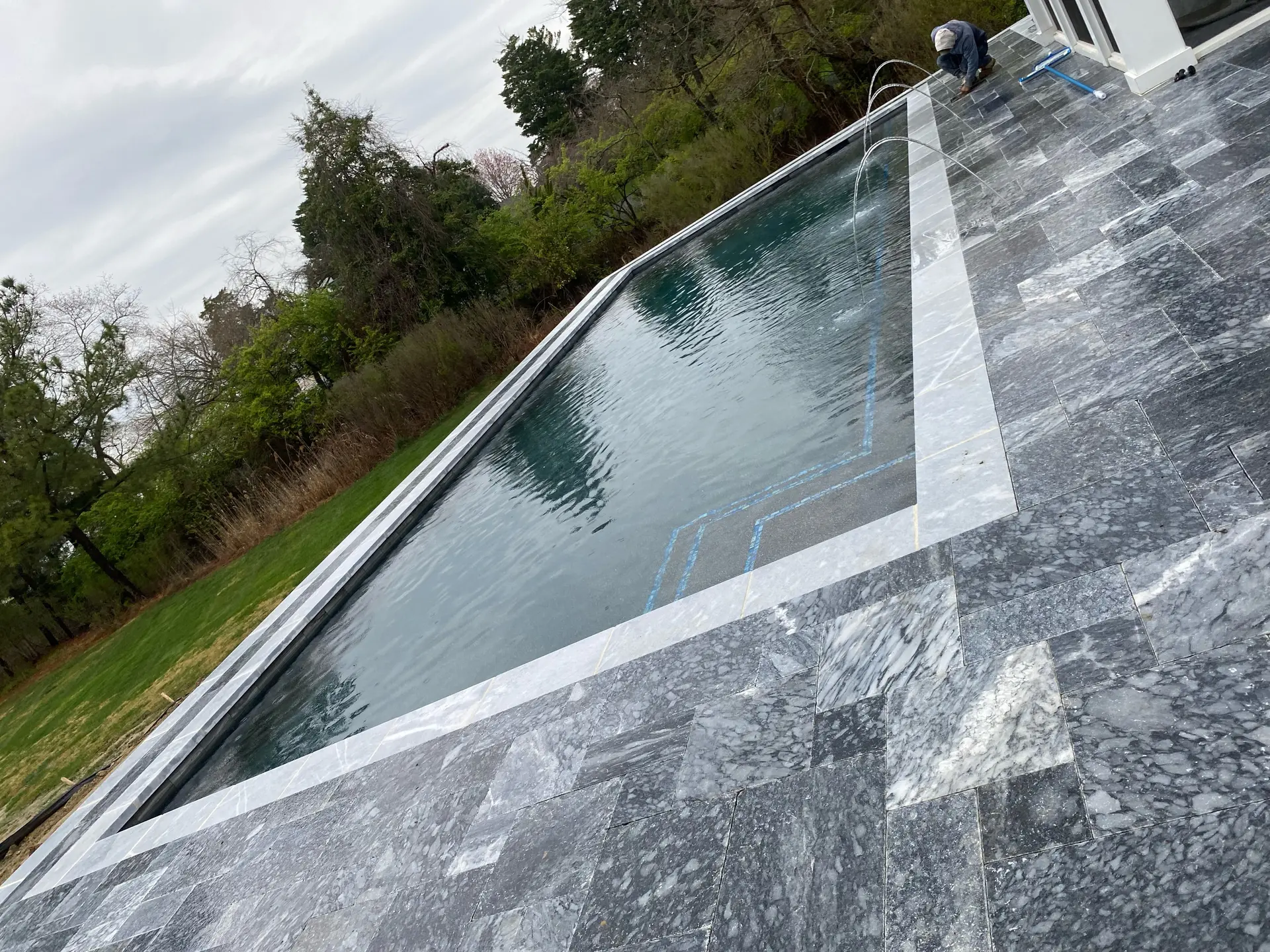Dramatic angled view of a marble-clad pool with bluestone coping