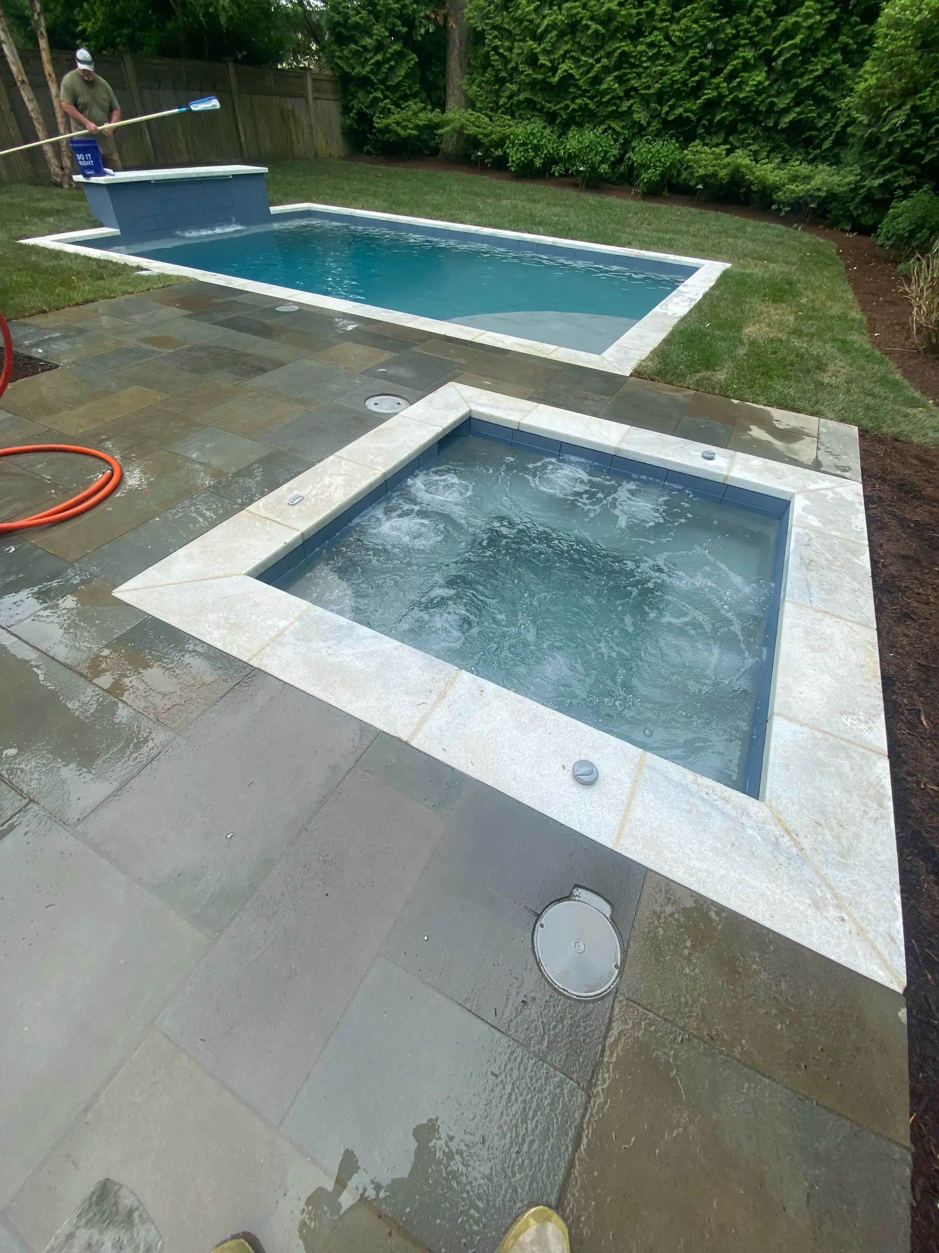 Pool and raised spa with bluestone and travertine deck